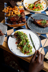 A group of friends enjoys a flavorful spread of beautifully presented dishes on a colorful table. Fresh ingredients and diverse flavors create a delightful dining experience