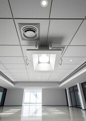 A white square led downlight installed in an office interior showcasing the modern lighting design with suspended tiles on high ceilings creating a clean aesthetic Empty room interior design Ultra