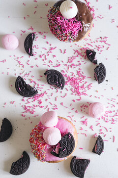 donuts with crushed cookies, marshmallow and extra sprinkles, on a white background