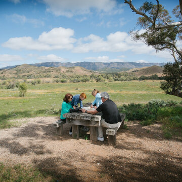 Family having a rest at a wooden table in the outback