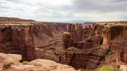 Fototapeta premium View of dramatic canyons with towering rock formations and cloudy sky in the late afternoon light