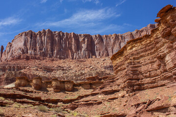 Vibrant rock formations and towering cliffs showcase the beauty of desert landscape in midday sunlight