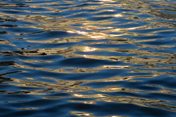 abstract nature background, water surface with waves at sunset