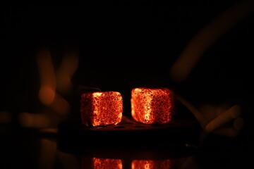 Glowing coals with glitch style lighting, enriched by noise, effect and grain details, create a mystical atmosphere in the dark. A vivid sense of heat and depth surrounds the image
