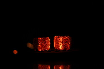 Glowing coals with glitch style lighting, enriched by noise, effect and grain details, create a mystical atmosphere in the dark. A vivid sense of heat and depth surrounds the image