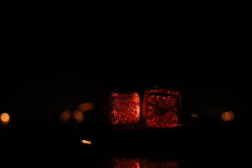 Glowing coals with glitch style lighting, enriched by noise, effect and grain details, create a mystical atmosphere in the dark. A vivid sense of heat and depth surrounds the image
