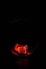 Glowing coals with glitch style lighting, enriched by noise, effect and grain details, create a mystical atmosphere in the dark. A vivid sense of heat and depth surrounds the image