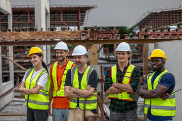 A group of civil engineers from different ethnicities and experiences stands with arms crossed expresses unity, solidarity and confidence in a factory. Inclusivity workers in a construction.