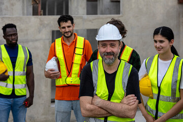 Group of engineers from different cultures stands behind his senior supervisor to support his...