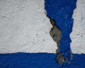 Cracked concrete wall with painted stripes.