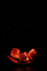 Glowing coals with glitch style lighting, enriched by noise, effect and grain details, create a mystical atmosphere in the dark. A vivid sense of heat and depth surrounds the image