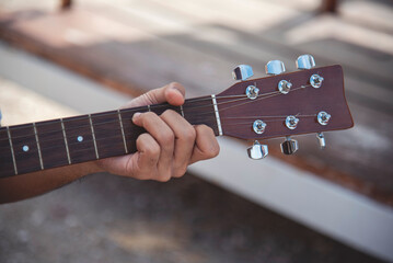 Handsome men playing acoustic guitar outdoor in green park. young man playing acoustic guitar music instrument at home, young Asian musician lifestyle in beautiful nature. Happy guitarist