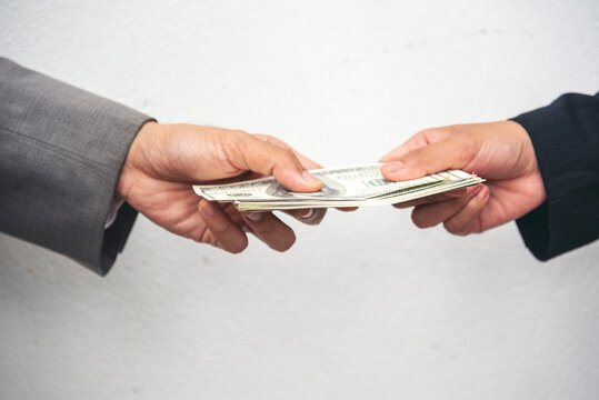 Close up hands giving money bribe payment. Hands holding dollar bill bribery financial economy business people. Business people corrupt illegal settlements try to pay graft. Corruption bribe concept