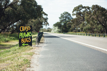 Roadside sign advertising fresh crays prawns and bugs for sale horizontal