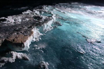 Captivating close-up of icy crystalline textures and vibrant turquoise hues, portraying a frozen, surreal landscape bathed in dramatic lighting, conveying mysterious beauty and serenity