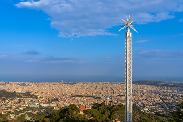 Aerial panorama view of Barcelona city with drop tower of the amusement park on moutain Tibidabo in summer with blue sky, Barcelona, Catalonia, Spain