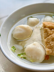 Clear fishball soup with tofu skin and scallions – traditional Asian comfort food close-up