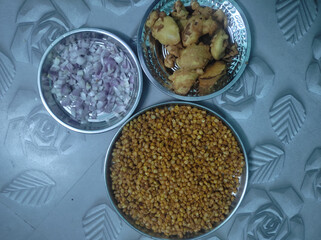 Indian street-style snack with crispy corn, aloo bajji, and chopped onions