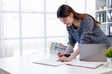 Business woman working at office with documents on his desk, doing planning analyzing the financial...