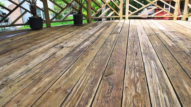 Wooden deck, weathered dirty wood planks at residential home house exterior potted plants, flower pots outside outdoors garden