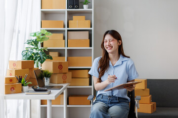 Young attractive asian woman sme owner startup business work happy with box at home prepare parcel...