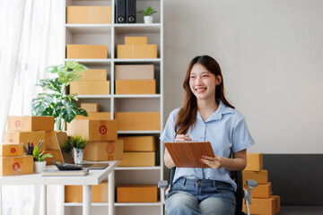 Young attractive asian woman sme owner startup business work happy with box at home prepare parcel...