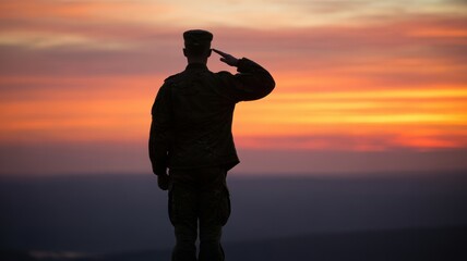 A soldier salutes against a vibrant sunset sky, standing in silhouette.