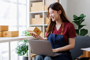 Startup small business sme entrepreneur or freelance Asian woman using a laptop with box, Young...