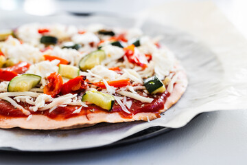 vegetarian pizza with zucchini capsicum and red lentil base on rustic homemade crust