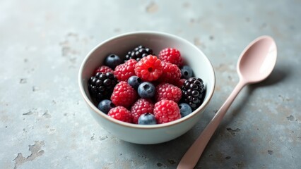 Fresh Mixed Berries in Bowl on Rustic Surface with Spoon