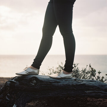 Young Woman Standing on Log