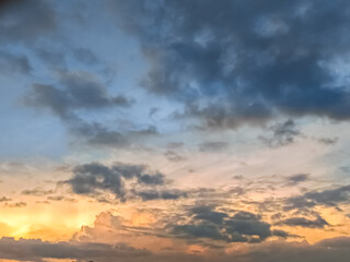 Dramatic cloudy sky during sunset with warm orange and cool blue tones blending together, capturing a peaceful and moody atmosphere.