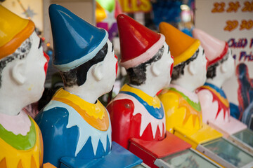 Row of brightly coloured clown heads turning