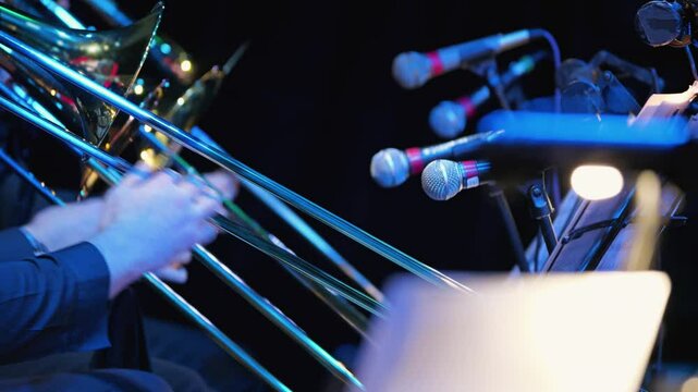A vivid scene of musicians playing the trombone surrounded by microphones. A close-up of a trombone player in a brass band