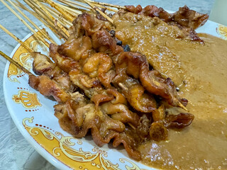 One plate of chicken satay with peanut sauce