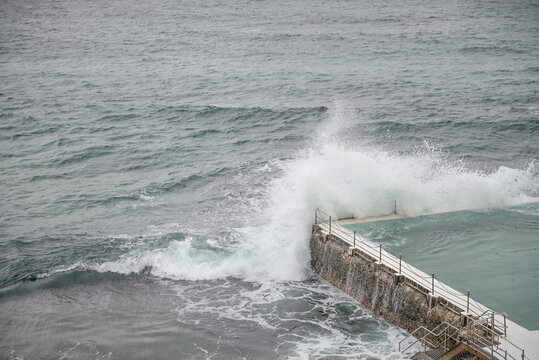 Waves breaking over seaside pool