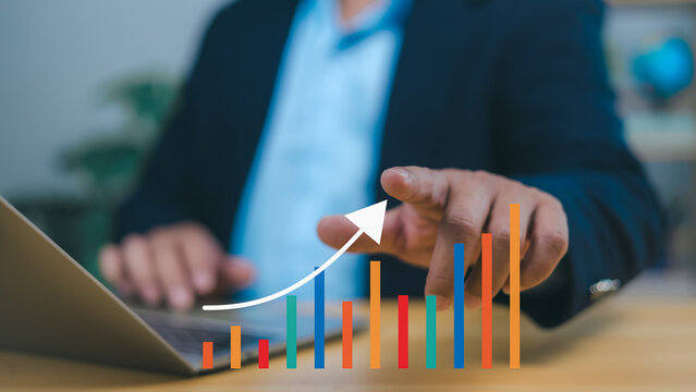 Person hand points to an upward-trending bar graph with a white arrow, symbolizing positive business growth, financial success, increasing market trends. Conveys prosperity and strategic progress.