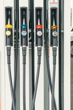 A rack of four petrol pump nozzles