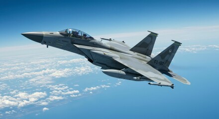 A sleek, grey fighter jet soars through a vibrant blue sky above fluffy white clouds, showcasing its aerodynamic design and advanced technology