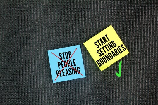 Colored paper with the words STOP PEOPLE PLEASING - START SETTING BOUNDARIES. focus on recognizing your own needs and limits, communicating them clearly