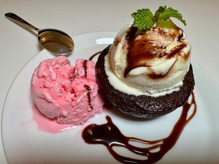 A portion of chocolate lava cake with ice cream and special sauce