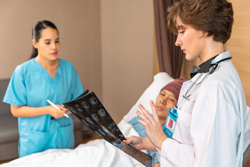 Asian man cancer patient visiting young female doctor for medical consultation in clinic. male patient struggling with cancer, healthcare. Medicine concept.Female doctor explaining xray to patient.