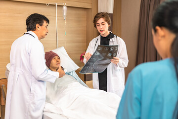 Asian man cancer patient visiting young female doctor for medical consultation in clinic. male patient struggling with cancer, healthcare. Medicine concept.Female doctor explaining xray to patient.