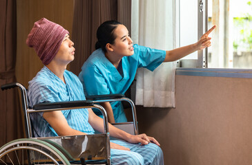 Cancer man patients in wheelchairs receive rehabilitation treatment at clinic. Young female doctor medical therapy treatments.Young patient with a smiling and friendly expression.