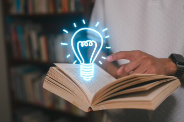a man holding book and Glowing light bulb icon in concept of knowledge is power. Self learning...