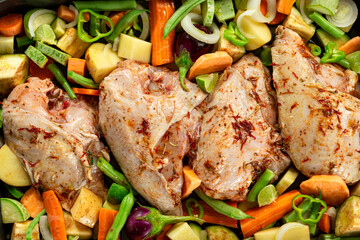 Close-up photo of marinated chicken breast with vegetables ready for oven.