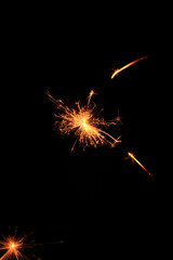 Fototapeta premium Yellow sparks fly on a black background, layered with grain, noise, and glowing effects to give a gritty, cinematic feel full of motion, contrast, and intense visual energy.