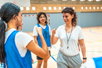 Female basketball coach motivating players during training