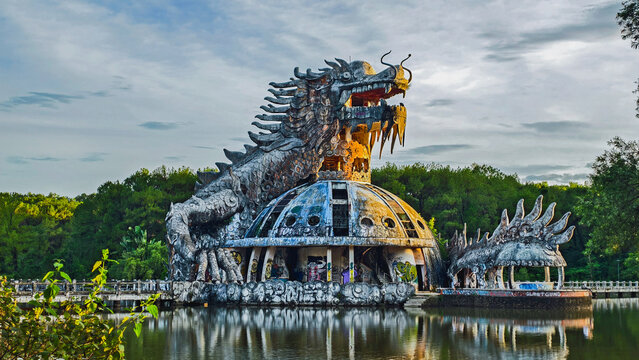 Abandoned dragon statue at Ho Thuy Tien Lake near Hue, Vietnam. Giant dragon sculpture in an abandoned water park. Dome-shaped structure surrounded by fores