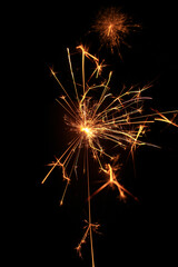 Yellow sparks fly on a black background, layered with grain, noise, and glowing effects to give a gritty, cinematic feel full of motion, contrast, and intense visual energy.